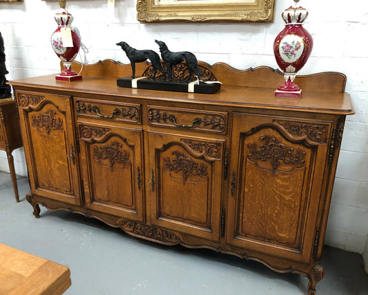 French Louis XV style Oak sideboard with beautiful carvings. Plenty Of storage space with four cupboards and two drawers. In very good original detailed condition.
