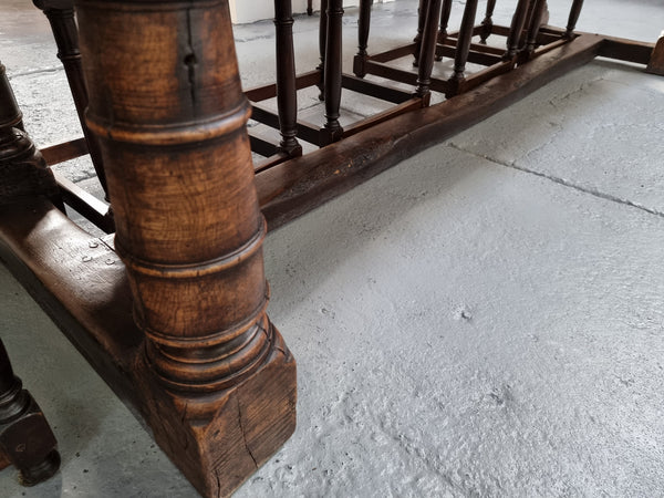 Amazing three meter long dark Oak Farmhouse dining table with a pedestal base. Comes with matched set of 10 very comfortable leathered chairs. All is in very good original detailed condition.