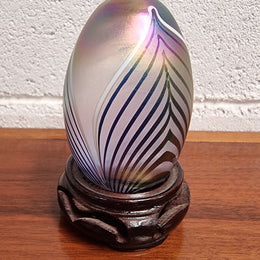 Iridescent glass egg shaped paper weight, on small wooden chinese stand. In good original condition. Please see photos as they form part of the description.