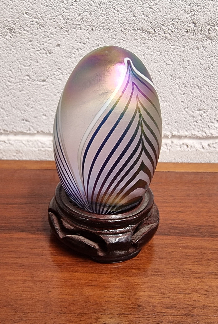 Iridescent glass egg shaped paper weight, on small wooden chinese stand. In good original condition. Please see photos as they form part of the description.