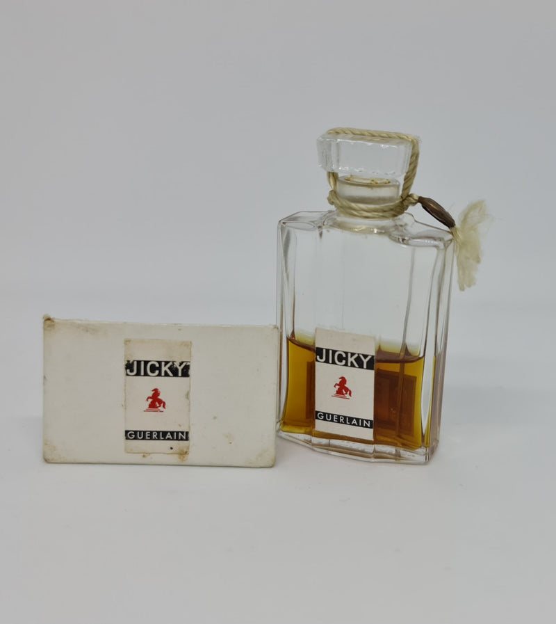 Vintage "Jicky" perfume bottle in great original condition with white base that it sits in.