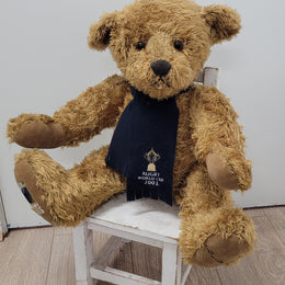 World Cup Rugby Bear. William by RUSS a special release for 2003. Limited to 5000 pieces worldwide. 50.8 cm fully jointed golden-brown bear with suedeen paw pads and blue scarf with Rugby World Cup Logo embroidery.

*Please note chair in photo is not included.