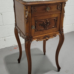 Beautiful French Walnut carved bedside cabinet with a lovely grey coloured inset marble top. The inside of the cupboard is also marble lined and it is in good original detailed condition.