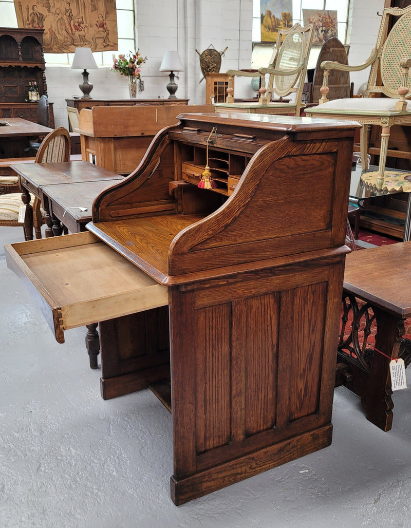 Charming petite English Oak fitted roll top desk. It has a very lovely fitted interior and a drawer at the front ideal for a unit or apartment. Sourced locally and in good original detailed condition.