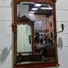 Decorative late 19th Century mahogany French wall mirror with brass swivel candle holders and brass detail. In good original detailed condition.