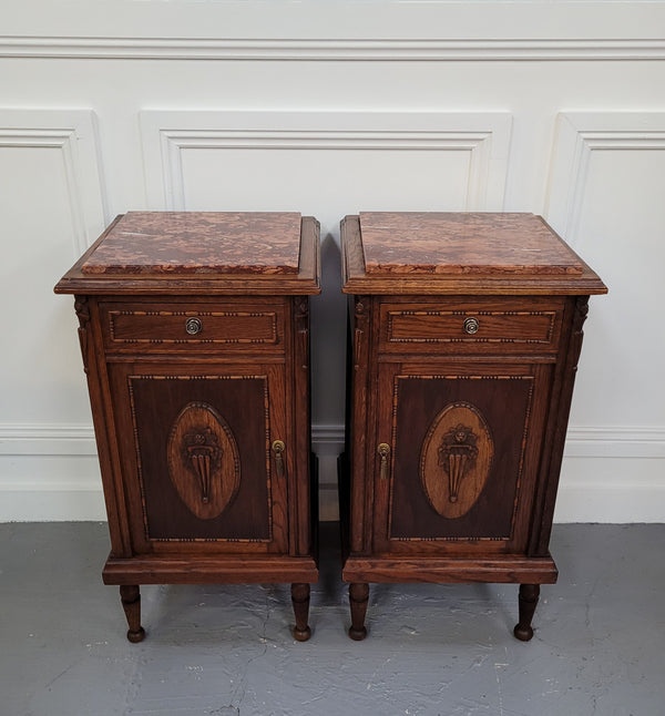 Pair of French Art Deco Oak and rouge inset marble top bedside cabinets. They have one drawer and one cupboard with elegant carving on the door. They have been sourced from France and are in good original detailed condition.