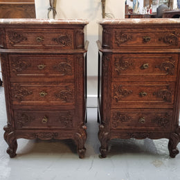 A pair of hard to find French Oak Louis XV style four drawer marble topped bedsides with attractive carvings. They are in good original detailed condition and have been sourced from France.