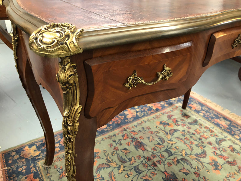An impressive French Walnut petite Bureau Plat with superb ormolu mounts, original tooled leather top with loads of character and drawers for storage. It is in very good original detailed condition.