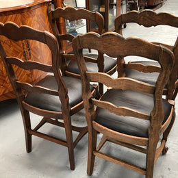 A set of four French Louis XV style, ladder back oak chairs. With finely carved detail and newly upholstered leather look seat. In great original condition. Chairs are comfortable and sturdy for everyday use.