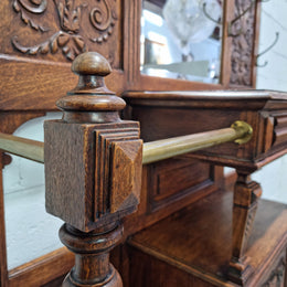 Grand Henry 2nd Style French Oak hall stand with 12 hanging hooks. Also has one cupboard and drawer for storage along with a mirror and two areas either side for umbrellas and walking sticks. In good original detailed condition.