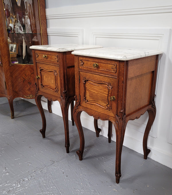 Pair of French Antique Louis XV style Oak marble top night stands. They have beautiful carved cabriole legs and beautiful white marble along with a drawer and cupboard for storage space. They have been sourced from France and are in good original detailed condition.