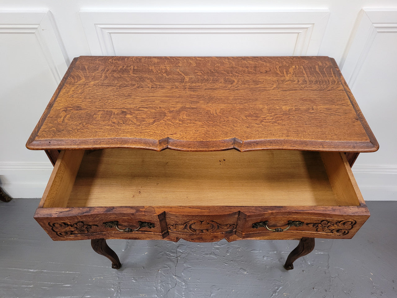 Vintage French dark Oak Louis XV style chest of three drawers. It has beautiful cabriole legs, elegant brass handles and decorative carving throughout. It is in good original detailed condition and has been sourced from France.