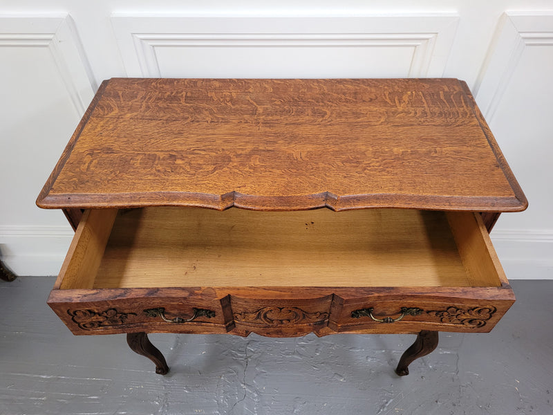 Vintage French dark Oak Louis XV style chest of three drawers. It has beautiful cabriole legs, elegant brass handles and decorative carving throughout. It is in good original detailed condition and has been sourced from France.