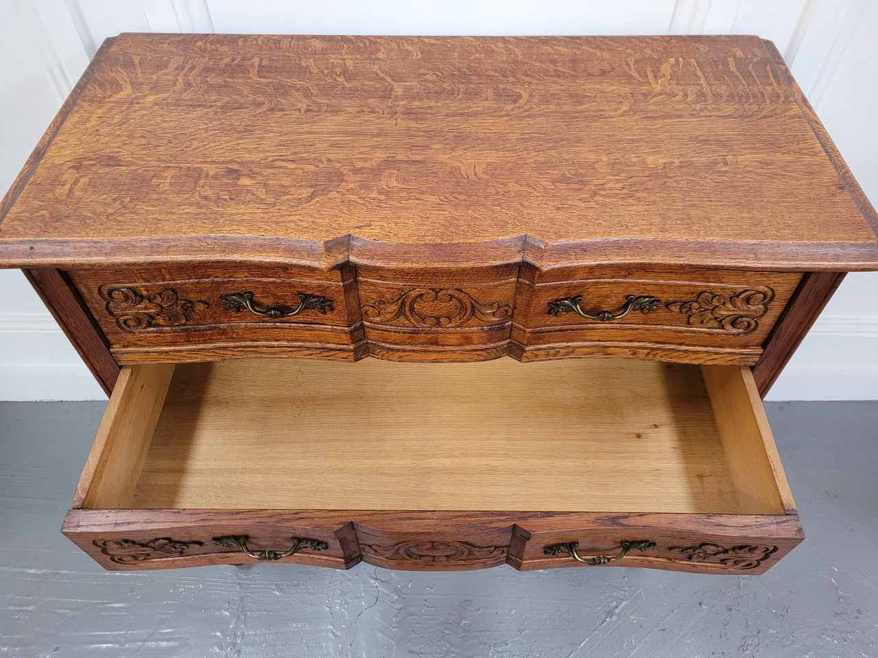 Vintage French dark Oak Louis XV style chest of three drawers. It has beautiful cabriole legs, elegant brass handles and decorative carving throughout. It is in good original detailed condition and has been sourced from France.