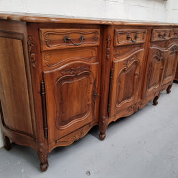 A Beautifully carved French Walnut Louis XV style four door sideboard. Plenty of storage space with four doors as well as four drawers. It is in good original detailed condition.