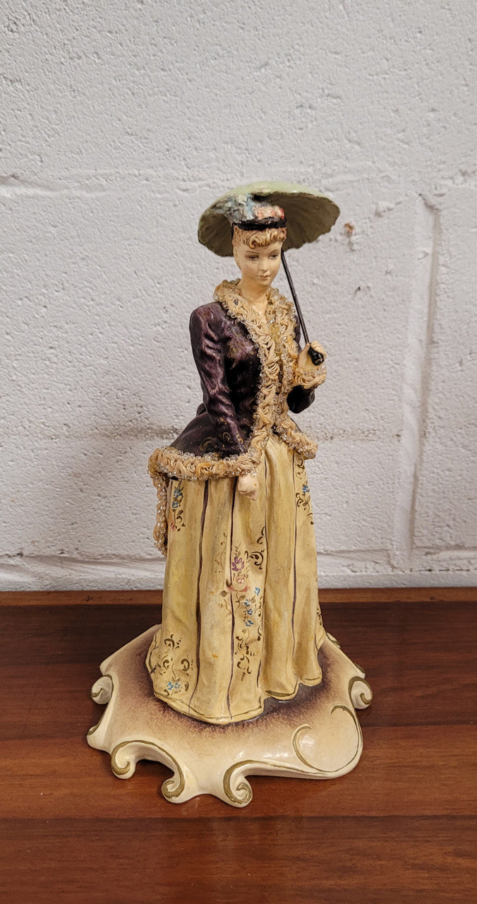 Vintage Italian figurine of lady holding umbrella signed. Sourced locally and in good original condition, please view photos as they help form part of the description.