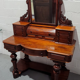 Beautiful Flame Mahogany Victorian duchess dressing table. Circa 1880 in date. It has a serpentine front outline and has an adjustable swing frame mirror. It is fitted with a central roll up storage section and then has three small drawers to either side, aswell as a central drawer in the middle of the serpentine front. It is in good original condition.