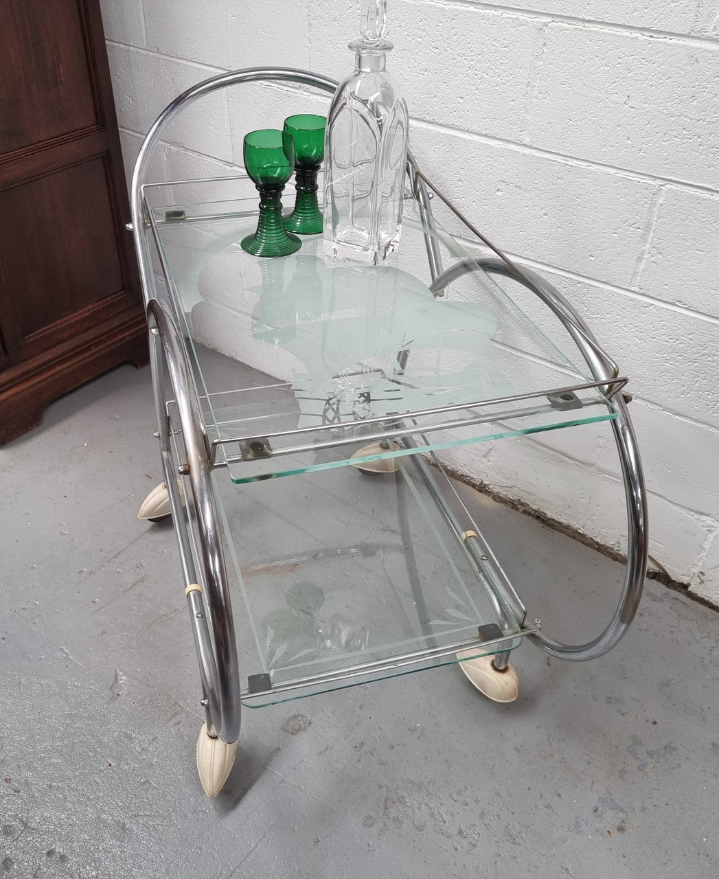 Stylish Art Deco chrome & frosted glass drinks trolley. Bakelite guards on the wheels. It is in good original condition and has been sourced locally.