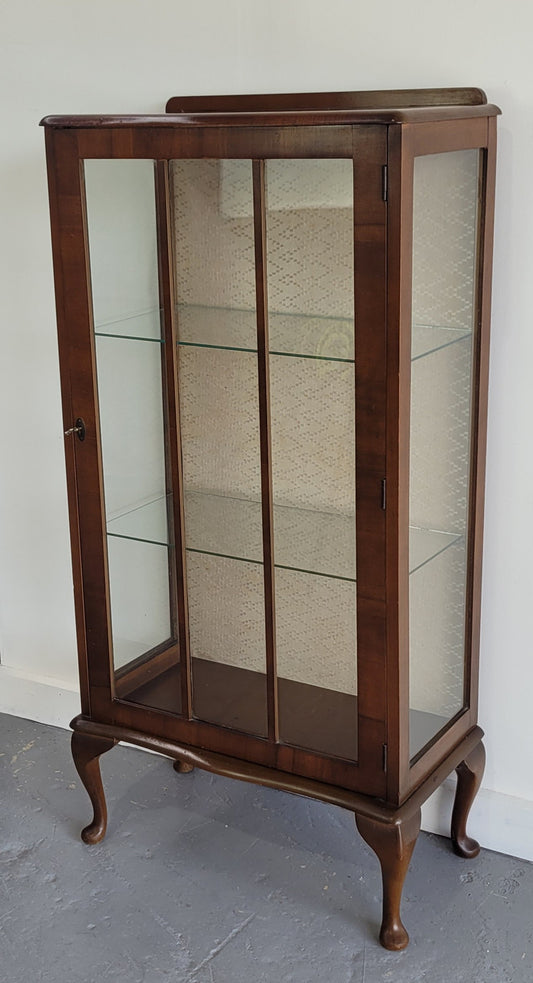 Petite single door Walnut display cabinet. Art Deco style with glass display door and two fixed shelves. In original condition.