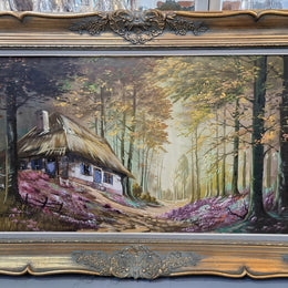 Vintage French oil painting on canvas in original gilt frame of "Forest Cottage Scene". Circa 1950's.