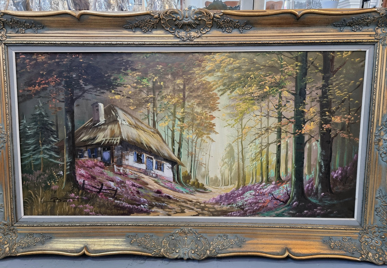 Vintage French oil painting on canvas in original gilt frame of "Forest Cottage Scene". Circa 1950's.