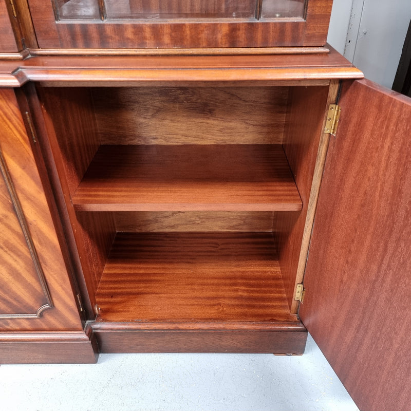 Georgian style Breakfront Flame Mahogany four door bookcase. A very impressive piece with plenty of storage and is of pleasing narrow proportions. It has been sourced locally and is in good original detailed condition.