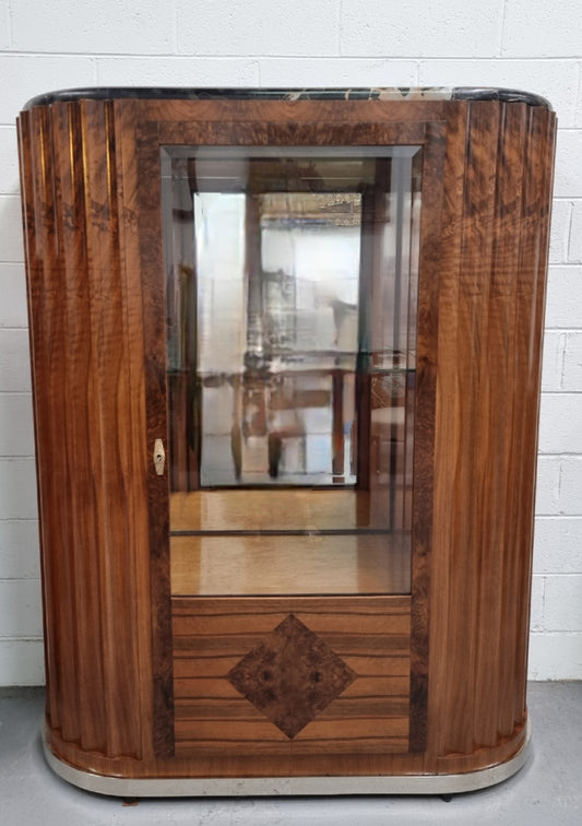 Stunning French Art Deco figured Walnut with Portoro marble top cocktail cabinet. Features chrome trim on base and glass display in door. It is in fully restored condition.