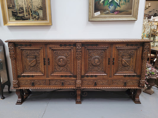 Large French Oak Renaissance style four door sideboard/buffet. Great decorative item with amazing carvings and stunning iron work on base. It is in good original detailed condition. Can pull apart completely making it easier to move.
