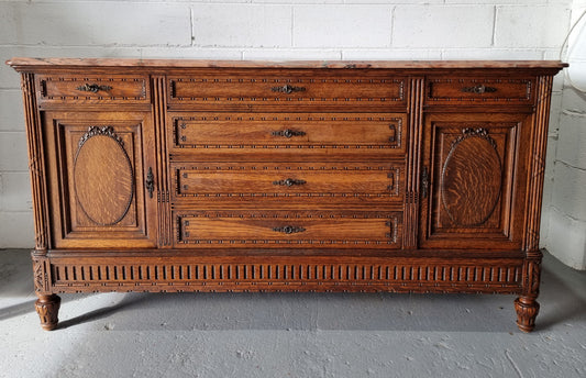 Absolutely beautiful French oak sideboard. It has 6 drawers and 2 cupboards for all your storage needs. There is a lovely coloured marble top and beautiful carving on the doors in good original detailed condition.