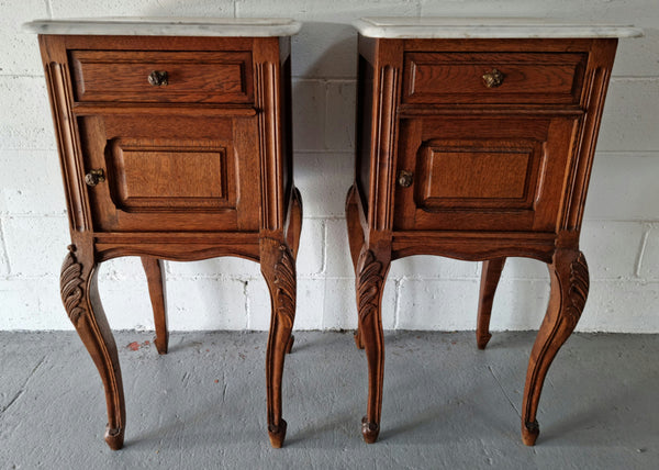 Lovely pair of French Oak bedside cabinets with marble tops, cupboard and drawer. In good detailed original condition.