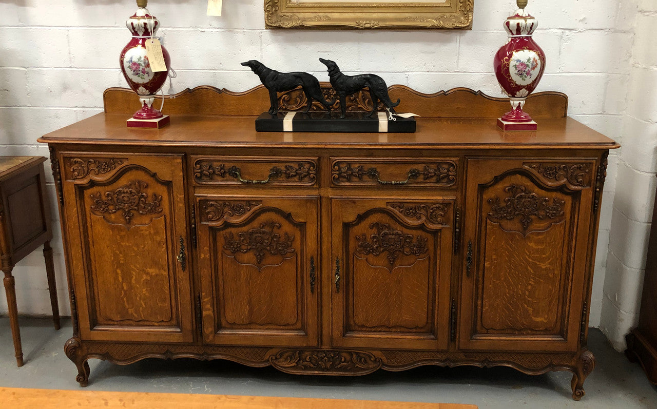 French Louis XV style Oak sideboard with beautiful carvings. Plenty Of storage space with four cupboards and two drawers. In very good original detailed condition.