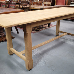 French raw Oak stretcher based refectory table. Features raw wood that could be used as is for a distressed look, or finished and waxed for a more refined look. Sourced from France and in good original condition.