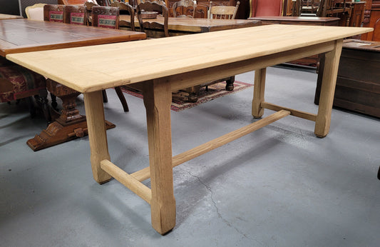 French raw Oak stretcher based refectory table. Features raw wood that could be used as is for a distressed look, or finished and waxed for a more refined look. Sourced from France and in good original condition.