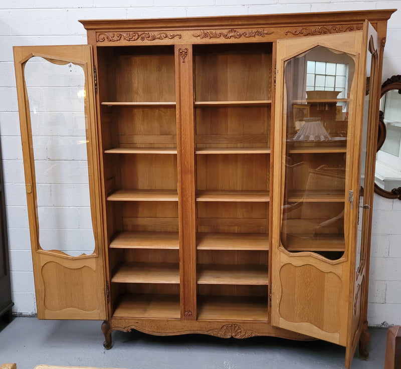 French Louis XV style light Oak three door bookcase with five fixed shelves. It has lovley glass doors and has been sourced from France. Is in good original detailed condition