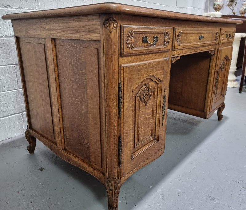 Fabulous French oak carved partners desk with a lovely parquetry top. It has three drawers and two cupboards on one side and two cupboards on the other side with no functioning drawers. It is in good original detailed condition.