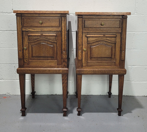 Beautiful pair of French oak bedside cabinets with marble tops. They have a drawer and cupboard for storage and are in good original detailed condition.