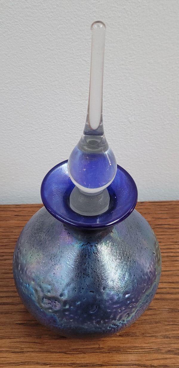 Stunning iridescent hand blown perfume bottle. Beautiful peacock blue, purple colours. Signed on base with clear glass stopper.