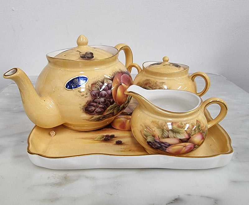 “Aynsley Orchard Gold” tea set on tray. Consisting of small teapot, lidded sugar and creamer. Please view photos as they help form part of the description.