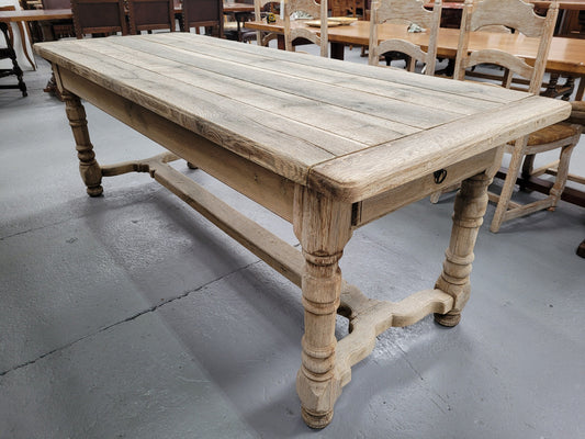 French stripped Oak pedestal stretcher base Farmhouse table with two drawers on either side of table. Features raw wood that could be used as is for a distressed look, or finished and waxed for a more refined look.