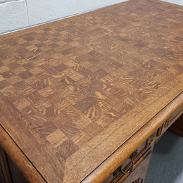 Fabulous French oak carved partners desk with a lovely parquetry top. It has three drawers and two cupboards on one side and two cupboards on the other side with no functioning drawers. It is in good original detailed condition.