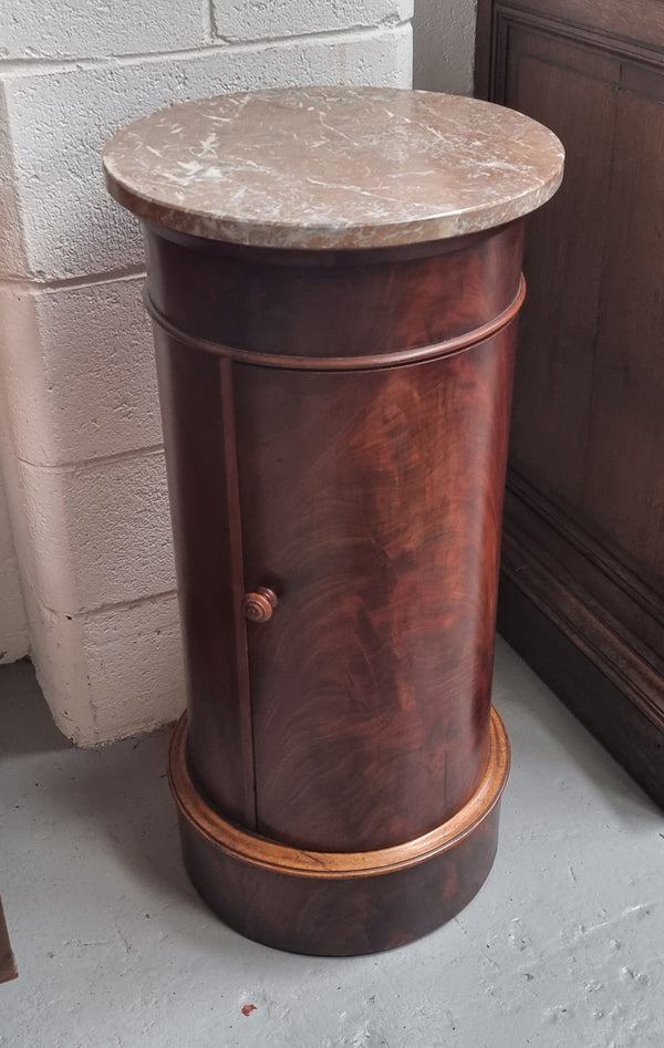 Unusual Empire flame Mahogany cylindrical marble topped bedside/pedestal. Would make an ideal pedestal with added storage inside or could be used as a bedside. Sourced from France and is in good original detailed condition.