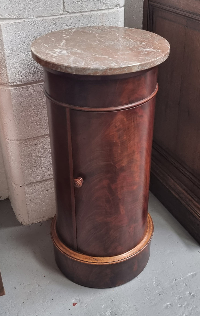 Unusual Empire flame Mahogany cylindrical marble topped bedside/pedestal. Would make an ideal pedestal with added storage inside or could be used as a bedside. Sourced from France and is in good original detailed condition.