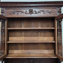 Grand French Oak Gothic style buffet with amazing detailed carvings. This stunning buffet has a display section at the top with two adjustable shelves, two drawers in the middle with elegantly carved handles and storage below with one fixed shelf. It is in good original detailed condition.
