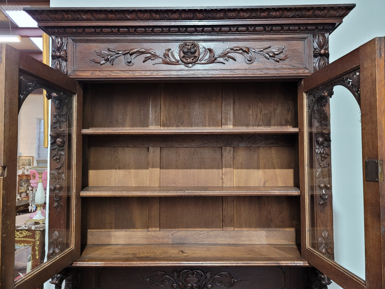 Grand French Oak Gothic style buffet with amazing detailed carvings. This stunning buffet has a display section at the top with two adjustable shelves, two drawers in the middle with elegantly carved handles and storage below with one fixed shelf. It is in good original detailed condition.