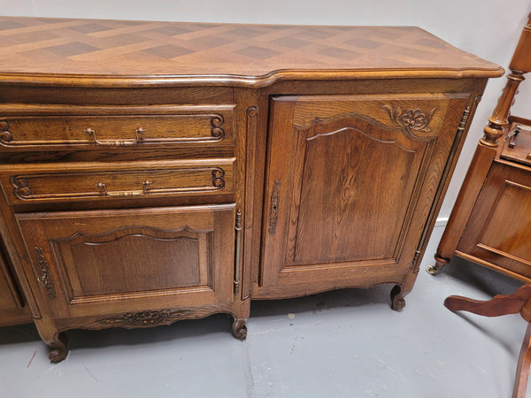 French Oak Louis XV style three door, two drawer, parquetry top sideboard. It has been sourced from France and is in good restored condition.
