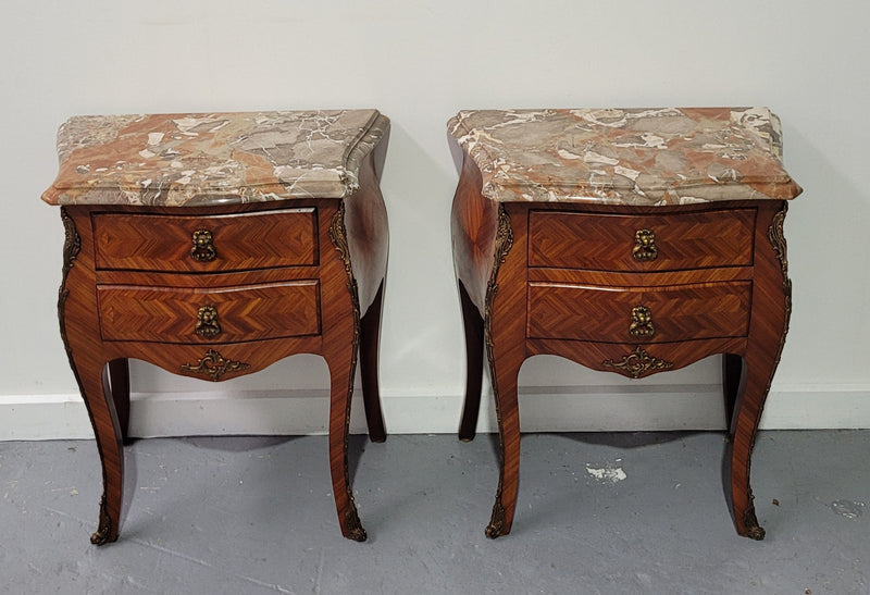 Pair of Louis XV commode style two drawer bedsides with beautiful marble tops and decorative mounts. They are a rare size and are in good, detailed condition.