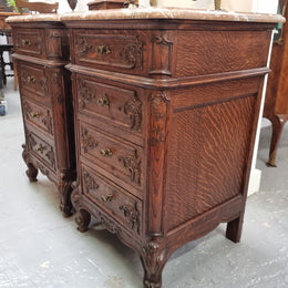 A pair of hard to find French Oak Louis XV style four drawer marble topped bedsides with attractive carvings. They are in good original detailed condition and have been sourced from France.