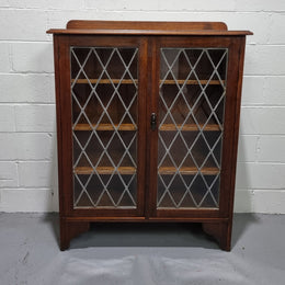 Lovely leadlight two door Oak bookcase/display cabinet with four wooden shelves. It is in good original detailed condition.