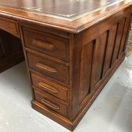 Lovely large English oak partners desk, with a beautiful burgundy tooled leather top. Plenty of storage space, both sides have 9 functioning drawers. It is in very good condition.