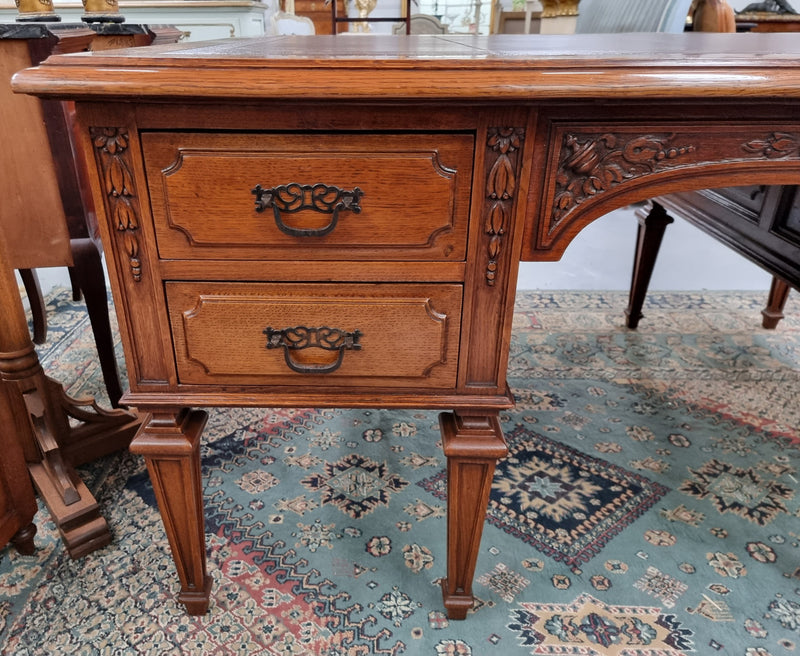 Substantial French Louis XVI style Oak partners desk. It has a beautiful leather top, two drawers on either side and decorative carvings throughout. Sourced from France and in good original detailed condition.